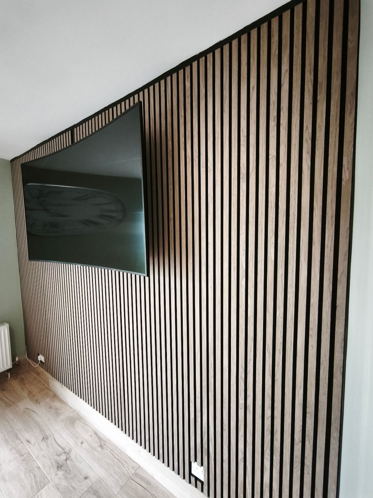 Acoustic slat panelling run flush into the corner and down to the floor, Dublin home