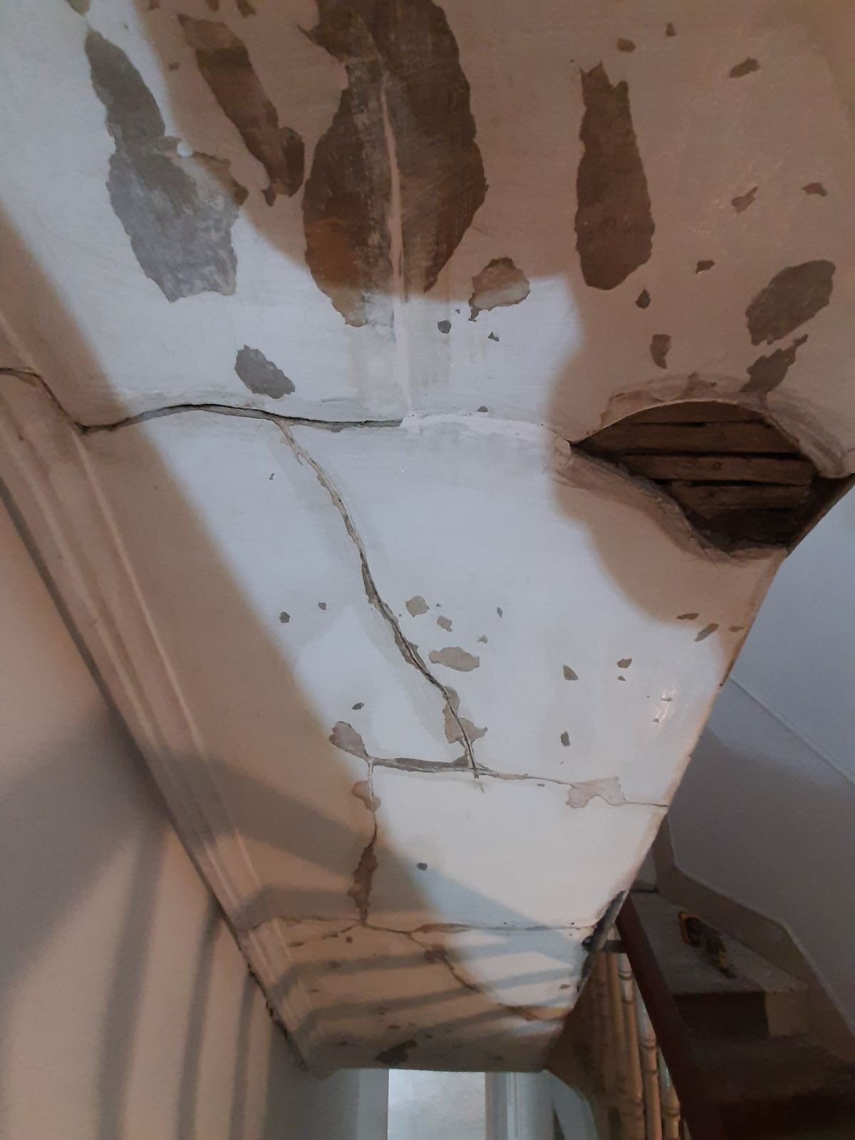 Cracked and flaking plaster on a period Dublin ceiling and cornice before wall preparation