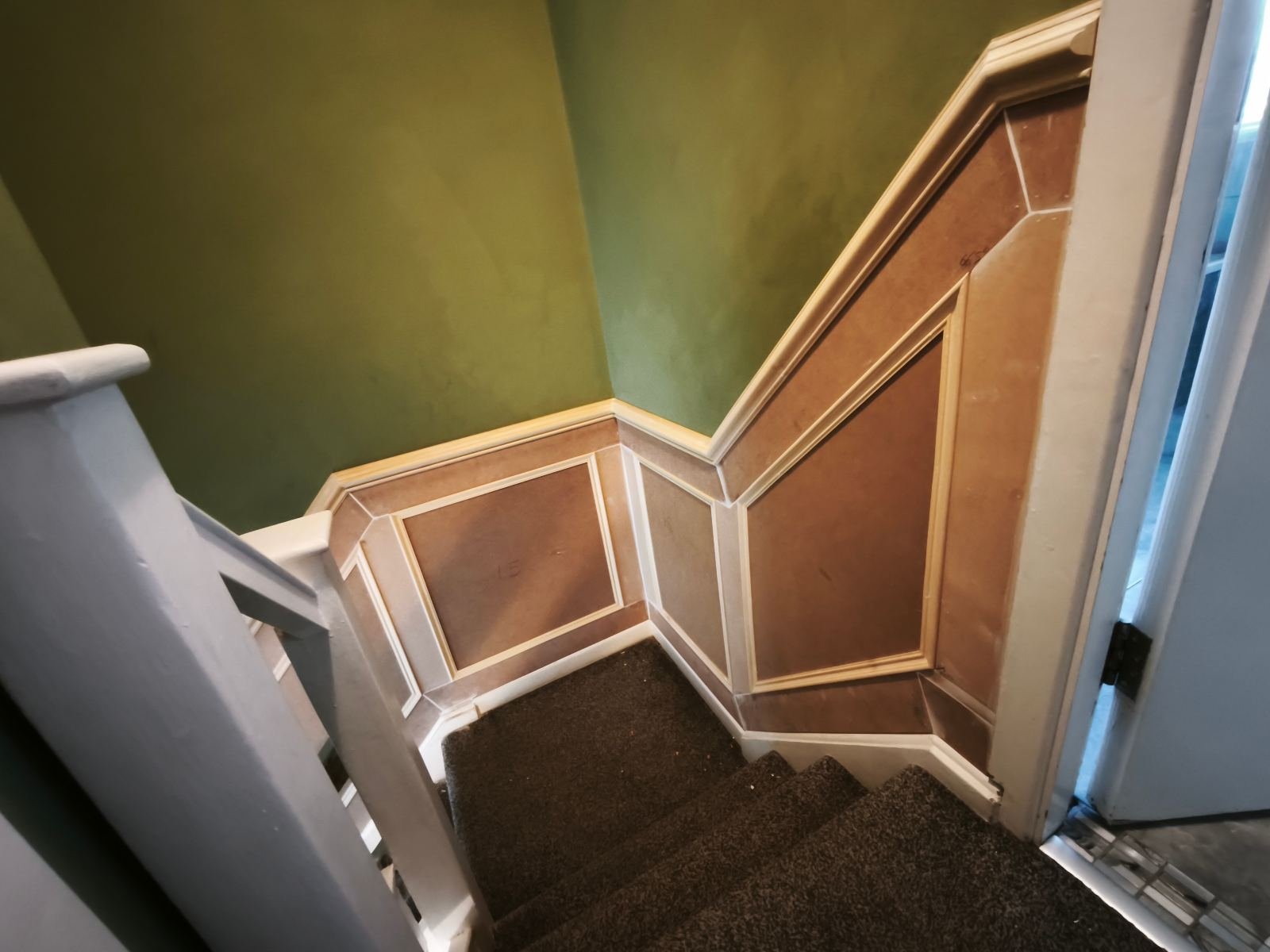 Recessed panel panelling following a staircase in a Dublin period home, mouldings set inside each square before painting