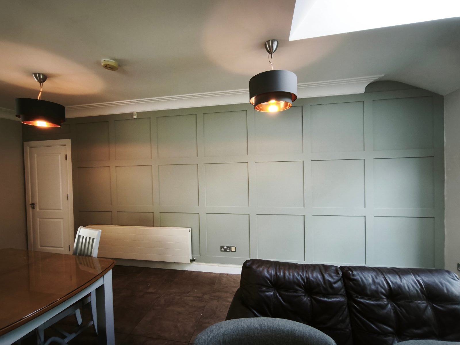 Sage green grid panelled wall