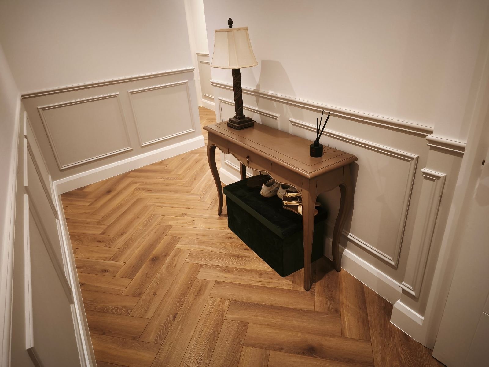 Traditional dado-height wainscoting in a Dublin hallway, painted soft white above herringbone flooring